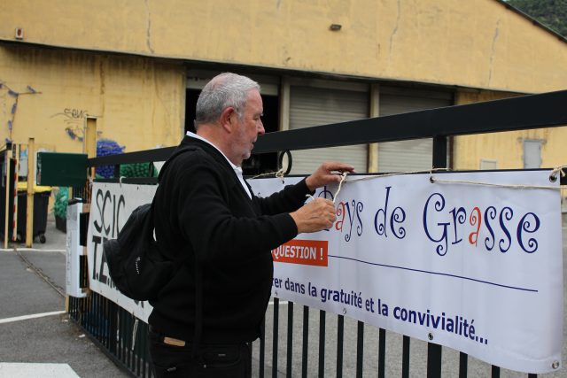 Philippe Caner accroche la bannière Repair Café Pays de Grasse à  l'entrée de Tetris